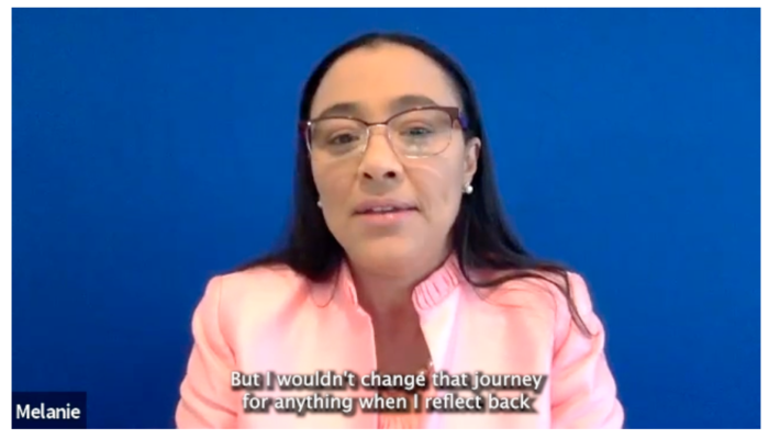 Screenshot from a Zoom interview shows a Black woman with glasses against a blue backdrop. 